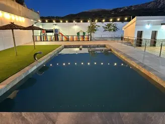 Piscina exterior iluminada de noche en casa rural La Villa de Alba