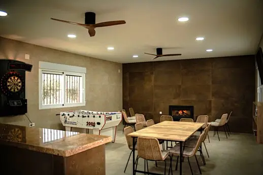 Zona interior de El Recreo de Alba con mesas de reuniones y chimenea